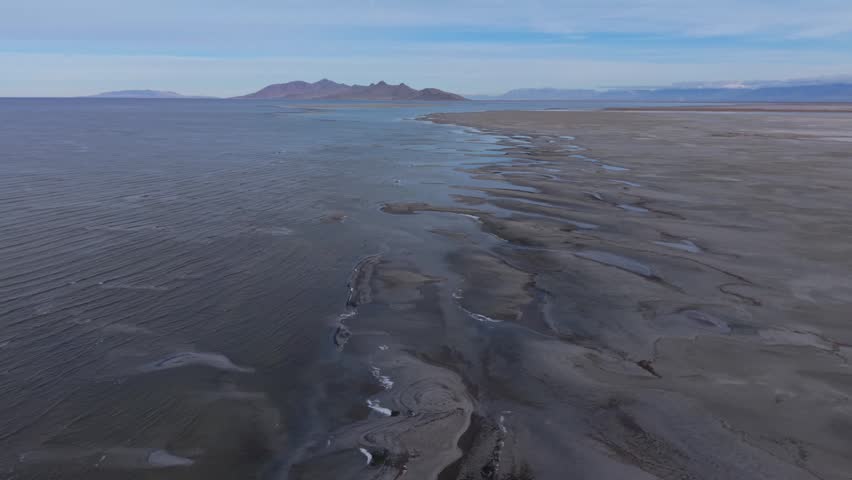 Aerial view of Great Salt Lake shoreline and industrial smelter in UT