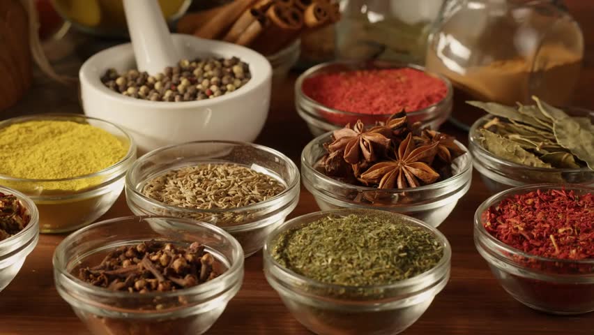 Close-up of various spices in glass bowls, highlighting Middle Eastern and Arabian cuisine, flavors, seasonings, and cooking ingredients.