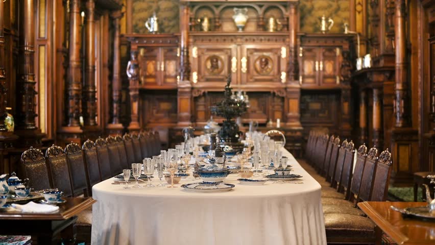 Elegant historical dining room with vintage furniture and porcelain set in grand luxury manor house.