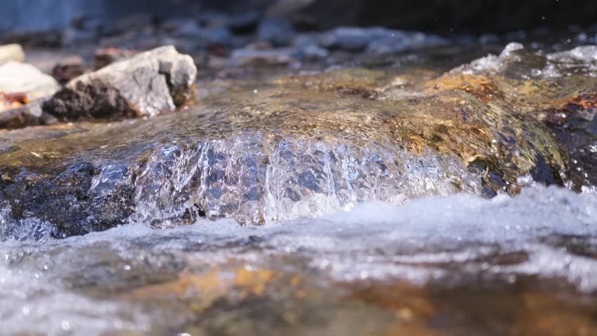 Clear mountain stream water flowing over rocks