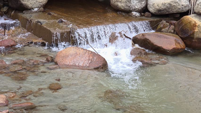 Close-Up of a Small Waterfall Cascading Over Rocks in a Rushing Mountain Creek	
