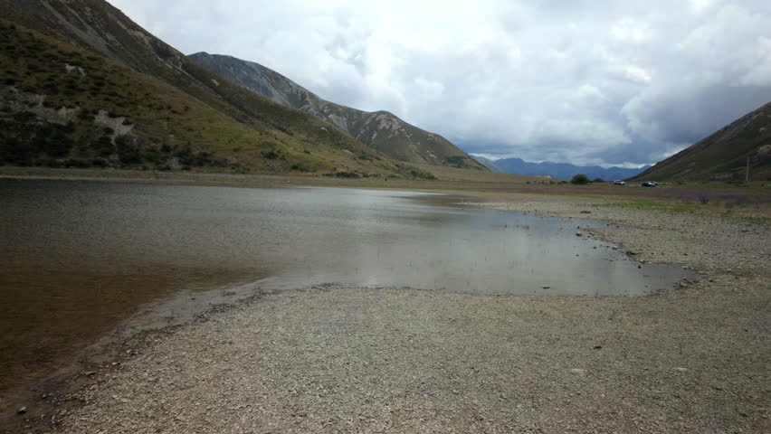 Mountain Lake In Broad Valley Under Cloudy Sky