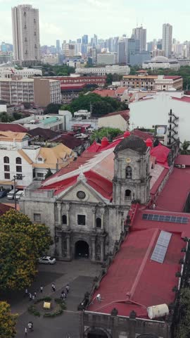 Aerial drone view of San Agustin Church in Intramuros, Manila, with colonial architecture and modern skyline in the background. Historic UNESCO landmark in Philippines.