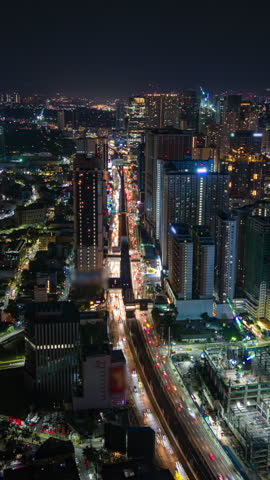 Aerial night timelapse of Manila, Philippines, showing busy city traffic, glowing skyscrapers, and urban skyline lights in a modern Southeast Asian metropolis.