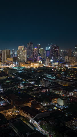 Aerial night timelapse of Manila skyline in the Philippines, featuring illuminated skyscrapers, glowing city lights, and modern urban architecture in a vibrant Southeast Asian metropolis.