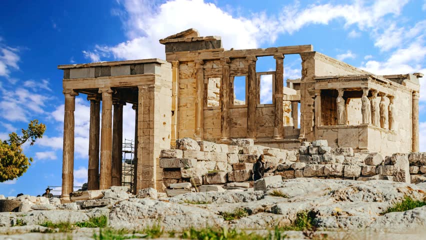 A detailed architectural view of the Erechtheion on the north side of the Athenian Acropolis. This 5th-century BC masterpiece of the Ionic order features the world-famous Porch of the Maidens, where six draped female figures (Caryatids) serve as supporting columns. A prime example of high classical Greek engineering and stone masonry under a clear Mediterranean sky.