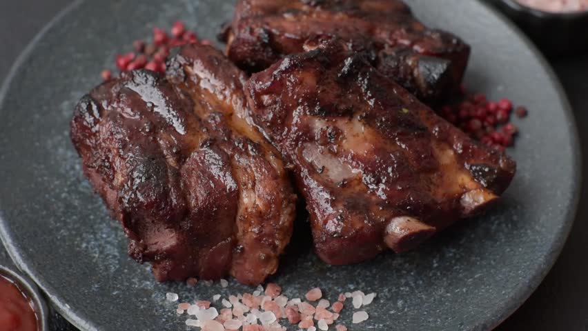 Grilled or barbecued pork ribs with sauce. Grilled ribs as a food background for your design