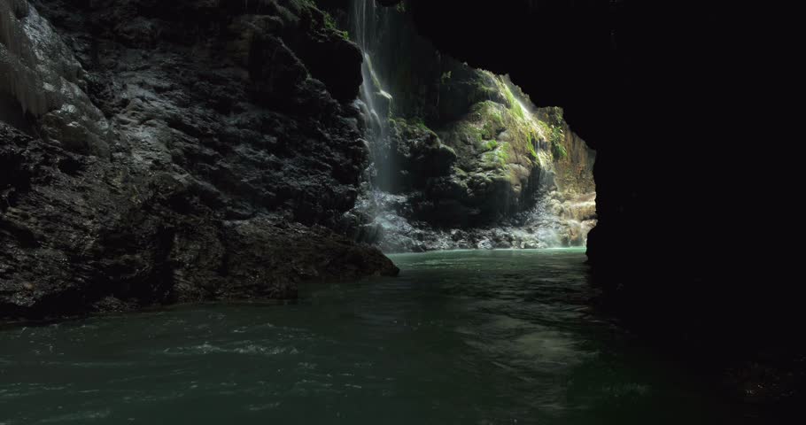 Low altitude drone shot of river bend flowing through tropical jungle canyon with smooth movement and lush surroundings.