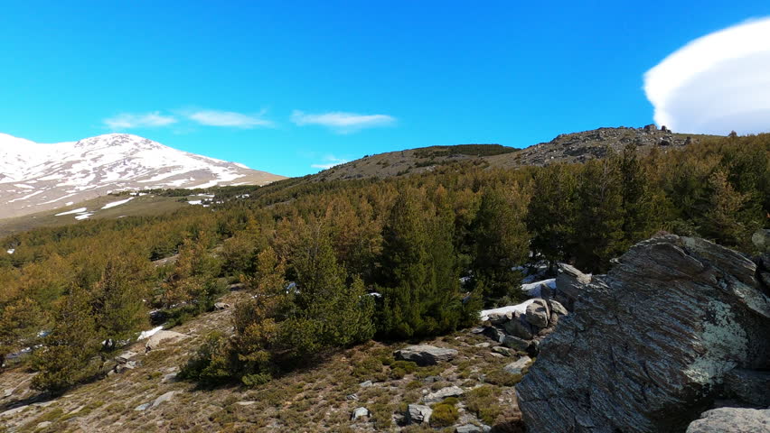 Panoramic view of the snow capped peaks of the Sierra Nevada Mountains revealing dramatic alpine landscapes and winter light in Spain