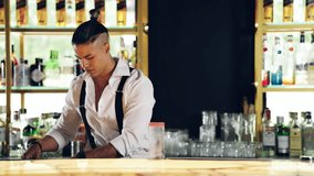 Focused mixologist skillfully preparing an alcoholic beverage. Stylish young man pouring liquor and mixing ingredients at a modern bar - Powered by Shutterstock - Get 15% off with code: PIKWIZARD15
