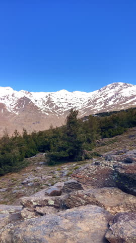 Panoramic view of the snow capped peaks of the Sierra Nevada Mountains revealing dramatic alpine landscapes and winter light in Spain