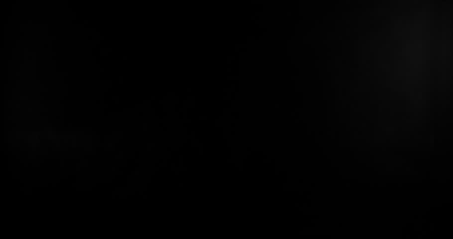 Super slow motion shattering glass filmed at 1000fps, side view with flying shards and dust isolated on black background. Perfect VFX overlay element for impact, crash or transition.