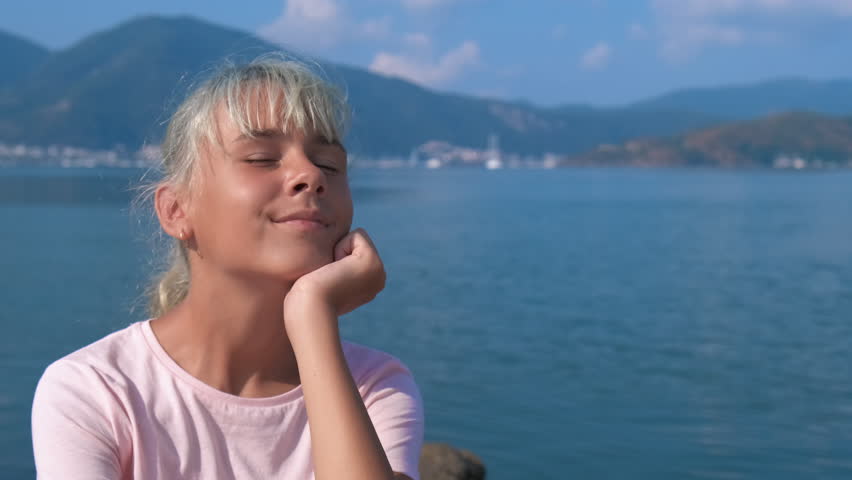 Portrait of a young girl enjoying the sea. A cute teenage girl dreams against the backdrop of a beautiful seascape