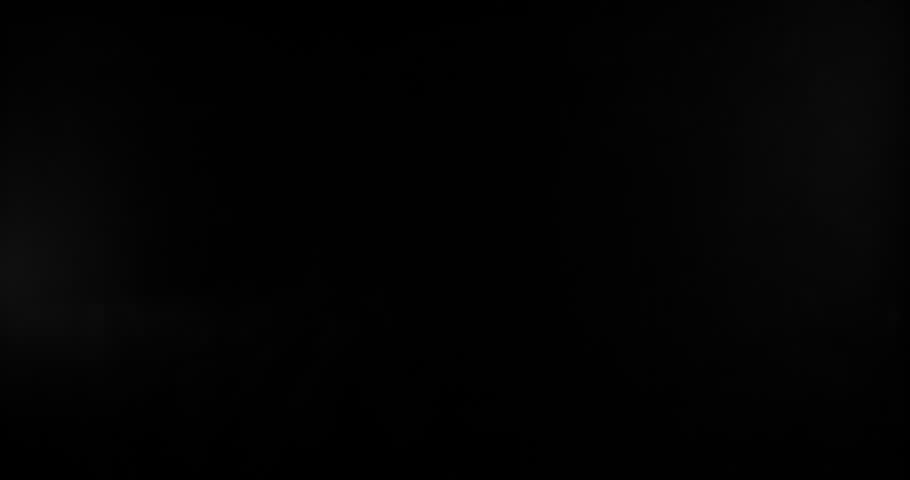 Super slow motion bullet impact shattering glass filmed at 1000fps. Side view of gunshot breaking window with flying shards and dust isolated on black background. Perfect VFX overlay element.
