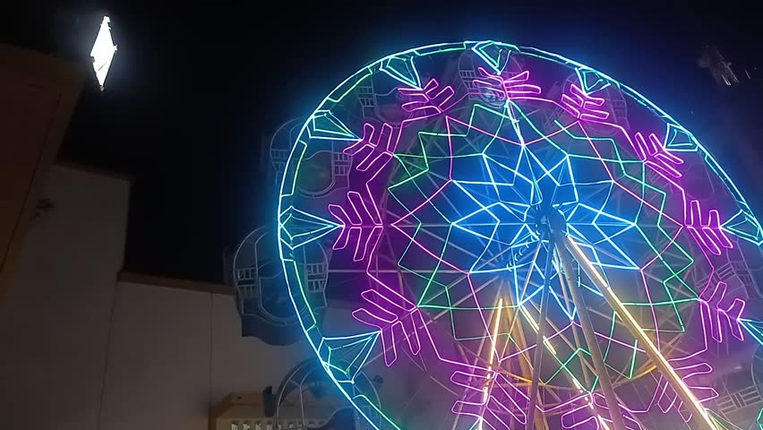 Colorful Carousel Merry-Go-Round Spinning at Night in Amusement Park