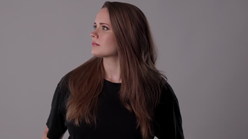 Beautiful young confident woman turning around and crossing her arms with a serious expression