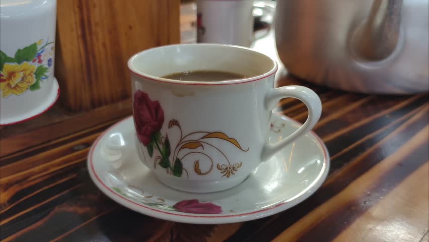 cup of hot coffee on wooden table