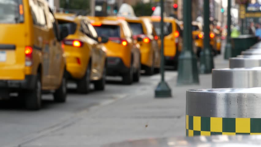 Manhattan Midtown street New York City, United States. Defocused row of yellow taxi cars. Many taxi cabs in line on 8th avenue near Penn Station. Taxi queue, urban road traffic, passenger transport.