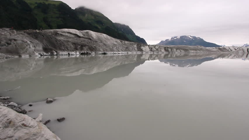 Glacier Retreat Forming Calm Meltwater Lake In Alaska Mountains