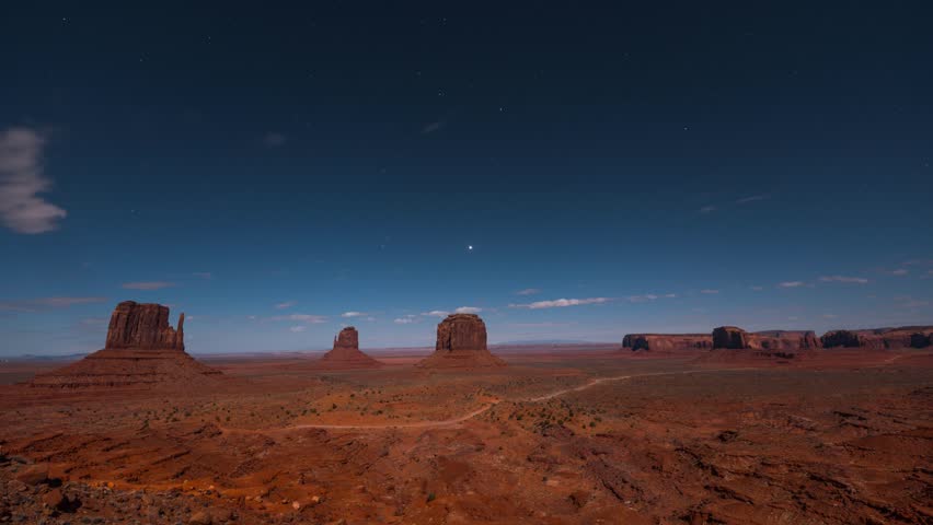 Starry night to sunrise transition over Monument Valley sandstone buttes, Arizona, scenic time lapse