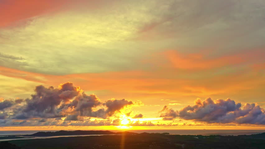 Aerial view of Golden sunlight breaks through layers of mist, painting the mountains with warmth and light. The colorful clouds shimmer in the morning air, creating a breathtaking harmony of nature.