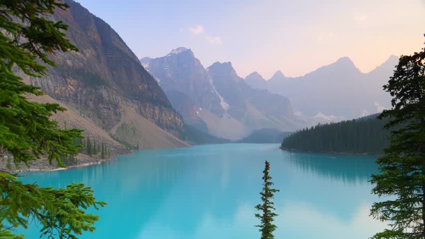 This 4K video captures Moraine Lake in Banff National Park, Alberta, Canada. The visual documents the turquoise water within the Valley of the Ten Peaks. The composition illustrates the glacially-fed lake and the surrounding rugged mountain ranges, documenting North American geography and Canadian landmarks for nature, science, and editorial media.