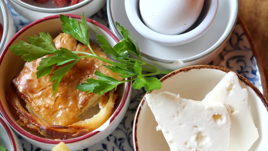 Authentic Turkish breakfast featuring a variety of dishes, captured in a close-up, dynamic shot showing fresh and delicious food items.