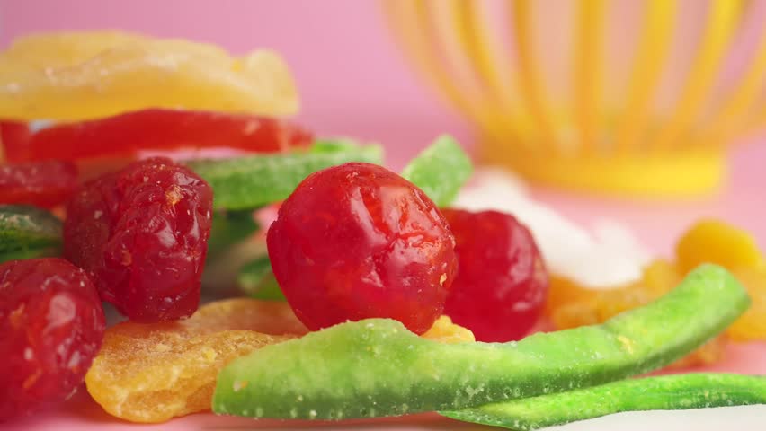 Panning over colorful assortment of sugary dried snacks. Cinematic close up of candied cherries ginger and pineapple.