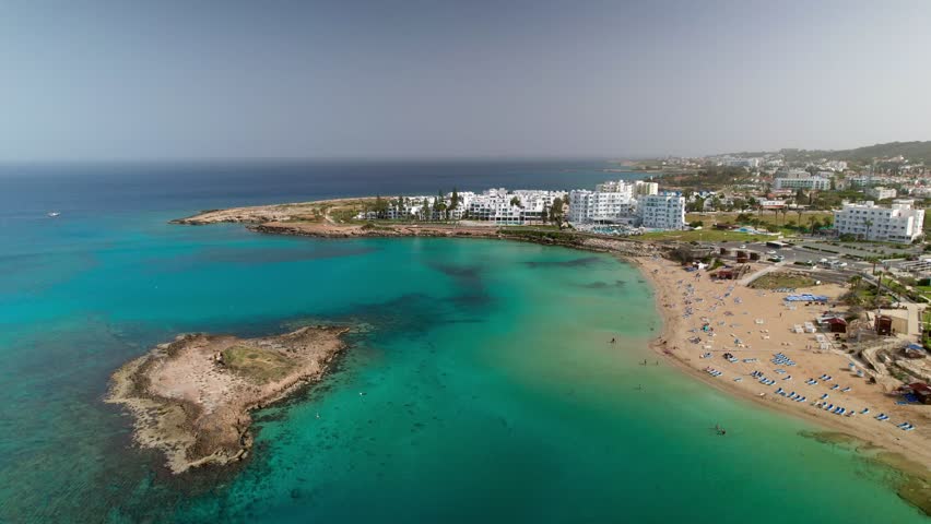 Aerial perspective of a beautiful sandy beach with turquoise water in paralimni, cyprus