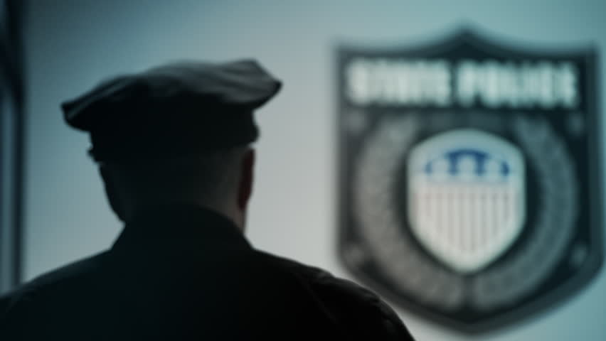 Middle-aged police officer completing criminal case paperwork in office