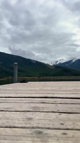 Woman sitting on dock at Vermillion Lakes in Banff National Park, Canada