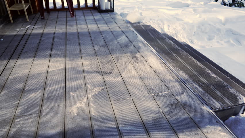 Bottom view: Snow being brushed off the terrace of a house.