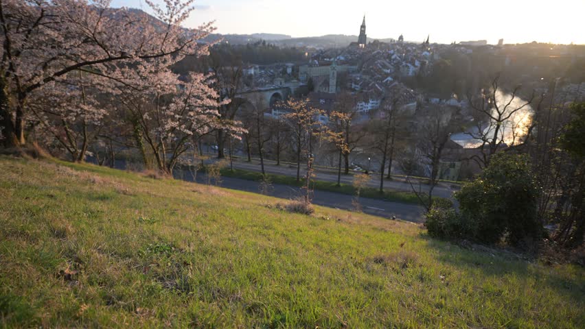Spring cityscape of Neuchatel, Switzerland with blooming trees and old town at sunset