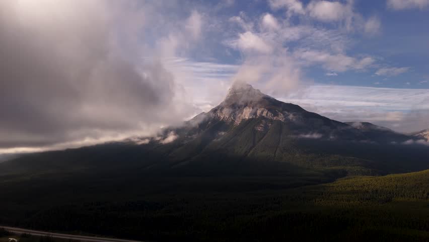 Majestic mountain peak covered in the clouds near Banff National Park, Alberta, Canada. Road trip in Canada. Rocky mountains. 4k footage