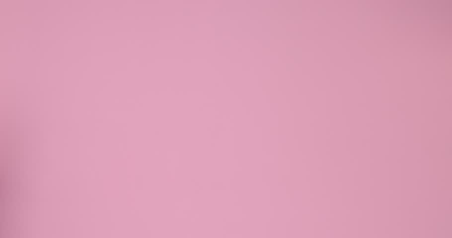 Little girl in swimsuit with beach bag on pink background