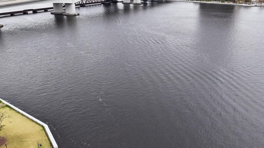 Aerial footage of cars driving over a bridge on the St Johns River in Jacksonville Florida USA