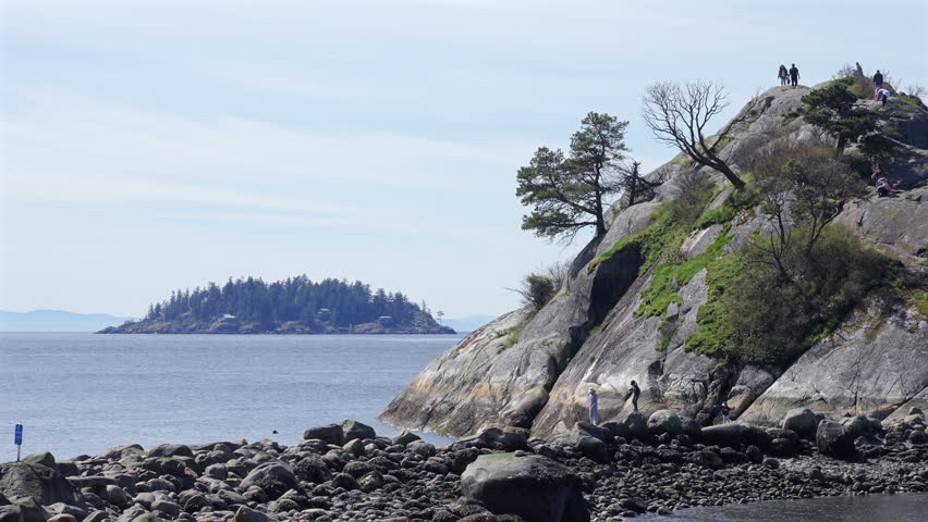 Establishing shot. Ocean view with mountains, small island, blue sky and white clouds at summer day in Vancouver, Canada, North America. Day time on April 2026. Still camera. ProRes 422 HQ.