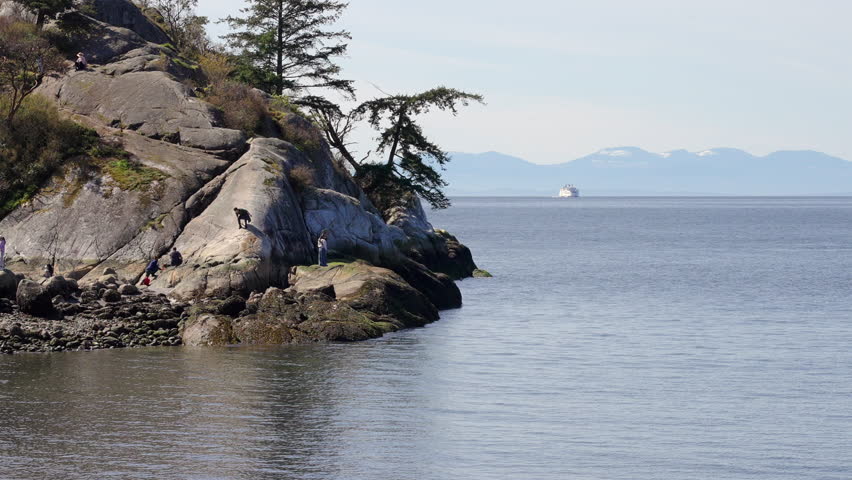 Establishing shot. Ocean view with mountains, small island, blue sky and white clouds at summer day in Vancouver, Canada, North America. Day time on April 2026. Still camera. ProRes 422 HQ.