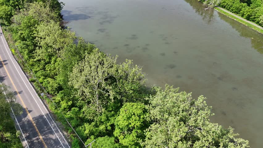 A shallow body of water acting as a marsh or swamp just past an aqueduct directing the water.