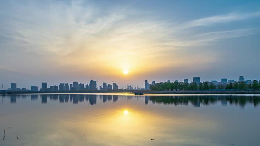 Time-lapse of Sunset over a City Lake, with Fiery Clouds Painting the Sky, Capturing the Dramatic Light Transition from Day to Night
