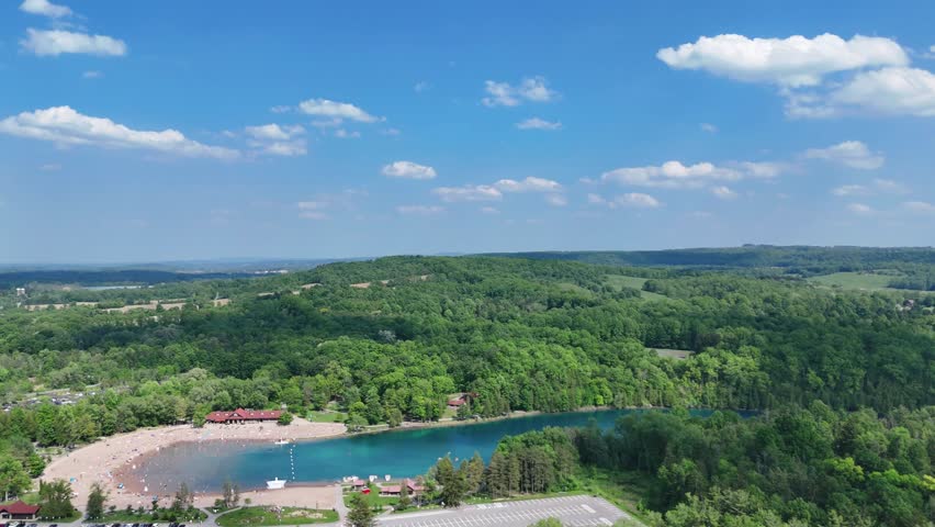 A beautiful breathtaking state park, a beach front full of people, and an amazing lake surrounded by an undulating forest.