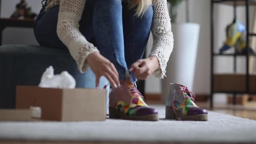 Female customer trying on shoes while shopping for footwear in shoe store. Young woman trying on modern shoes in shoe store. woman trying on shoes while shopping in shoe store.
