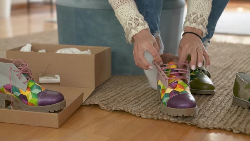 Female customer trying on shoes while shopping for footwear in shoe store. Young woman trying on modern shoes in shoe store. woman trying on shoes while shopping in shoe store.