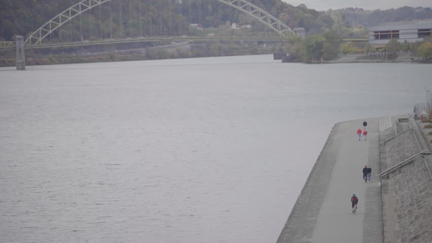 Arch Bridge Over River with Waterfront Walkway
