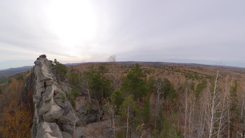 Picturesque rock massif in autumn. A majestic rock ridge with a panoramic view of the surrounding mixed forest and lake.