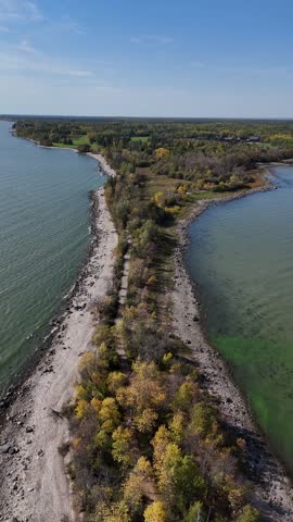 Vertical aerial drone shot of the peninsula on Hecla Island Manitoba. Drone moving backward revealing shoreline, Lake Winnipeg, forest, and trees along the island.