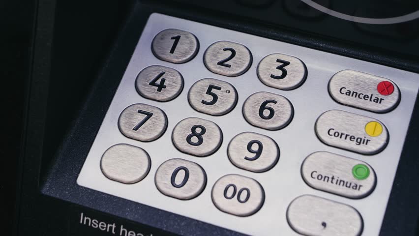 Close-up of hand entering PIN code on ATM keypad. Banking, finance, security and transaction concept.