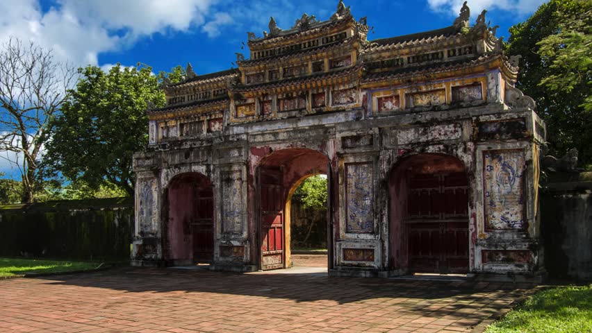 Hien Nhon Gate and eastern entrance of the UNESCO World Heritage site of Imperial Palace and Citadel in Hue, VietnamHue, Vietnam - Sep 1st 2025:  Ornate, weathered gate of Hien Nhon in the Imperial City of Hue, Vietnam, with intricate carvings, multiple archways, and surrounding greenery under a bright sky.