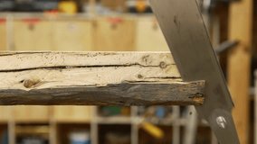 Carpenter cutting a wooden plank with a handsaw in a workshop - Powered by Shutterstock - Get 15% off with code: PIKWIZARD15