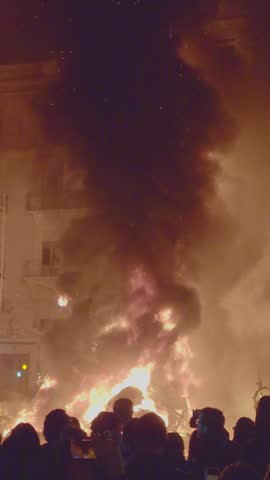 Valencia, Spain. March 19, 2026, Crowd watching a massive falla monument engulfed in flames and smoke during the Crema, the final night of the Fallas festival in Valencia
